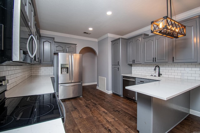 kitchen featuring dark wood-type flooring, crown molding, appliances with stainless steel finishes, and decorative backsplash