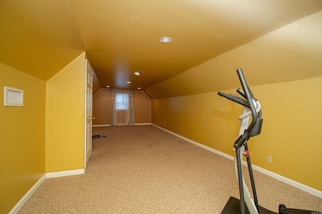 bonus room with lofted ceiling and light colored carpet