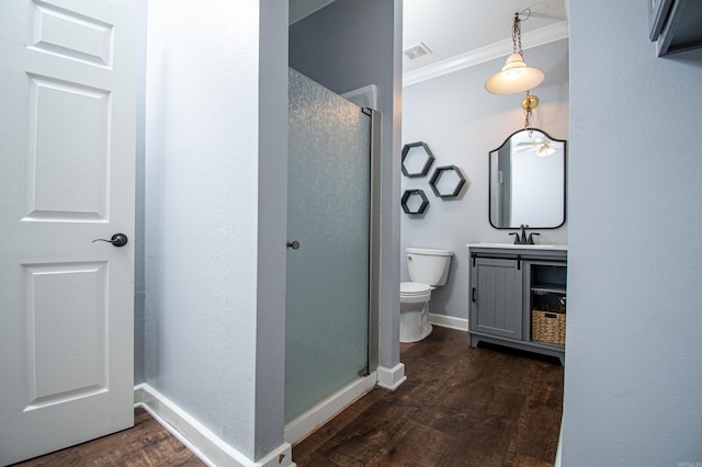 bathroom with toilet, a shower with shower door, hardwood / wood-style floors, and vanity