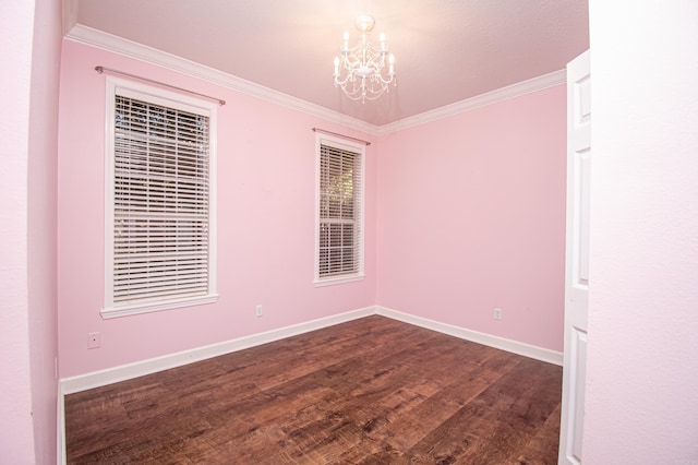 empty room with dark wood-type flooring, a notable chandelier, and crown molding