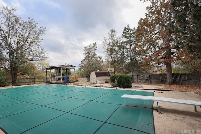 view of pool with a gazebo, a storage shed, a diving board, and a patio