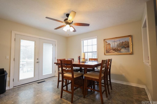 dining space featuring french doors, a textured ceiling, and ceiling fan