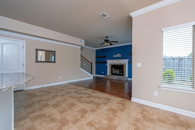 unfurnished living room with ornamental molding, a fireplace, light wood-type flooring, and ceiling fan