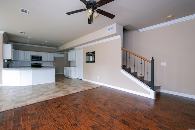 kitchen featuring light hardwood / wood-style flooring, white cabinetry, backsplash, and crown molding