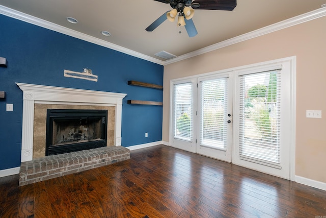 unfurnished living room with crown molding, a brick fireplace, dark hardwood / wood-style floors, and ceiling fan