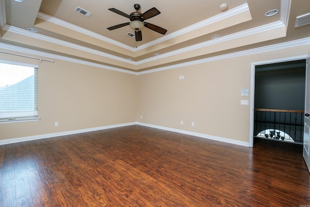 spare room featuring crown molding, dark hardwood / wood-style floors, a tray ceiling, and ceiling fan