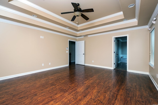 unfurnished room with dark hardwood / wood-style floors, a tray ceiling, ornamental molding, plenty of natural light, and ceiling fan