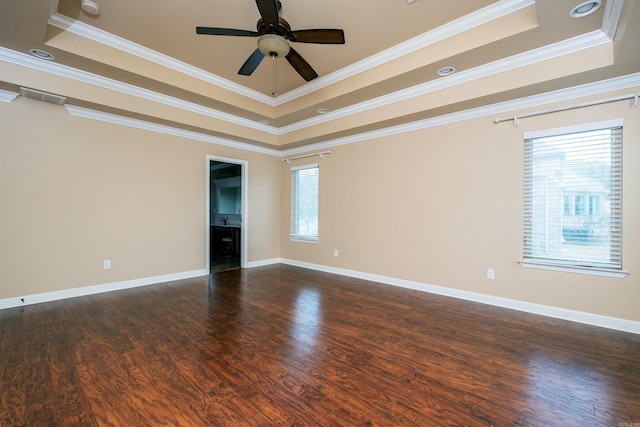 unfurnished room with crown molding, a tray ceiling, and dark hardwood / wood-style flooring