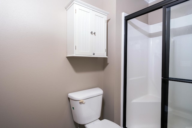 bathroom with toilet and a shower with shower door