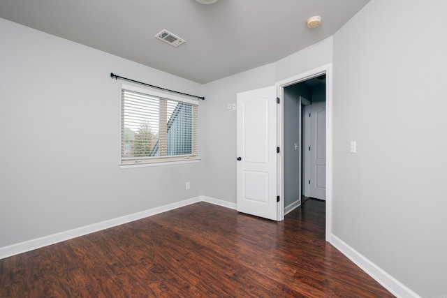 unfurnished room with dark hardwood / wood-style flooring