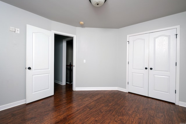 unfurnished bedroom with a closet and dark hardwood / wood-style flooring