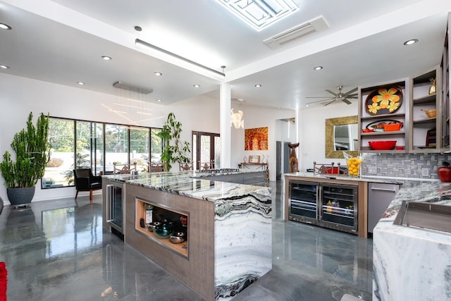 kitchen with wine cooler, light stone countertops, ceiling fan, and backsplash