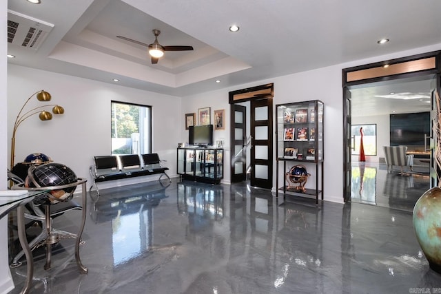 interior space with a tray ceiling and ceiling fan