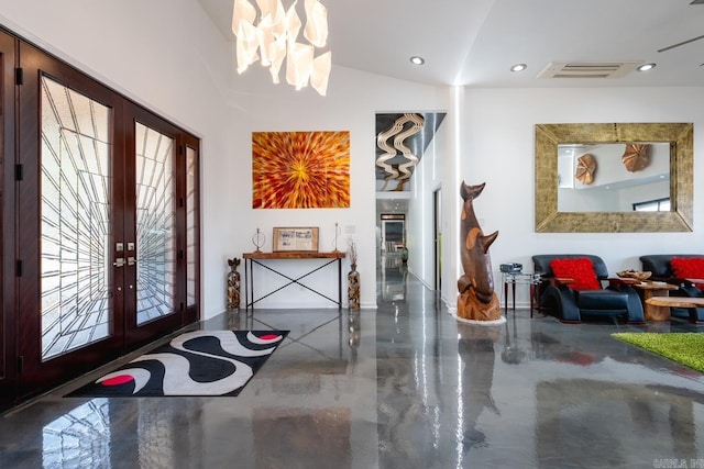 foyer with an inviting chandelier, french doors, lofted ceiling, and concrete floors