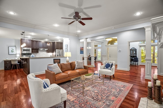 living room featuring decorative columns, ceiling fan, crown molding, and dark hardwood / wood-style flooring