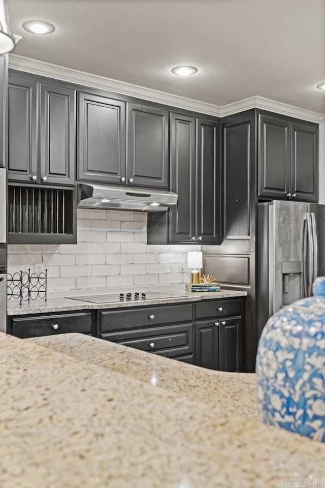 kitchen featuring crown molding, stainless steel appliances, light stone counters, and backsplash