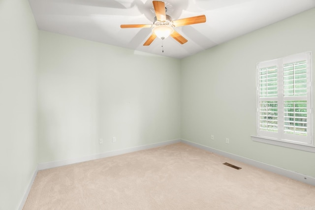 carpeted spare room featuring ceiling fan