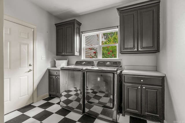 clothes washing area with cabinets and washing machine and clothes dryer