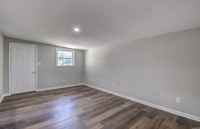 spare room featuring vaulted ceiling and dark hardwood / wood-style flooring