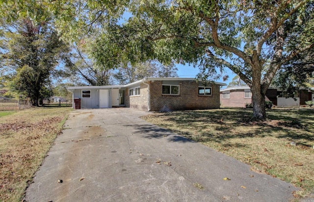 ranch-style house featuring a front yard and a carport