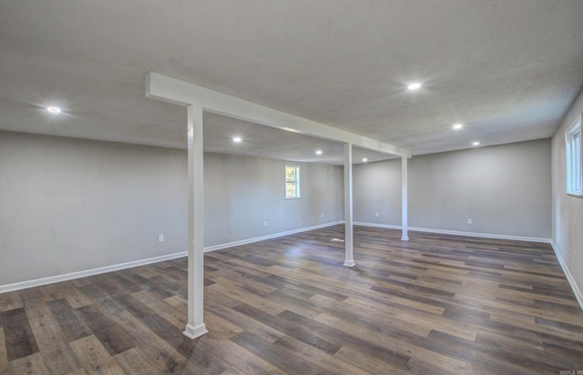 basement with a textured ceiling and dark hardwood / wood-style floors