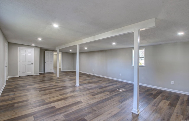 basement featuring a textured ceiling and dark hardwood / wood-style flooring