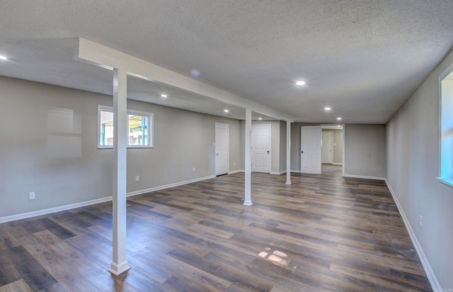 basement with a textured ceiling and dark hardwood / wood-style floors