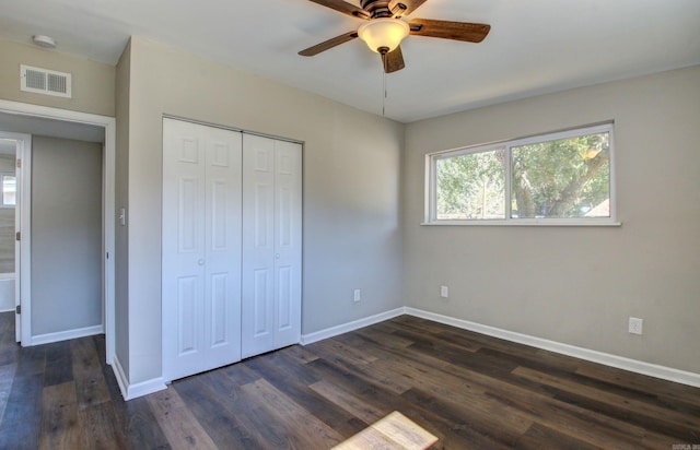 unfurnished bedroom featuring dark wood-type flooring, ceiling fan, and a closet