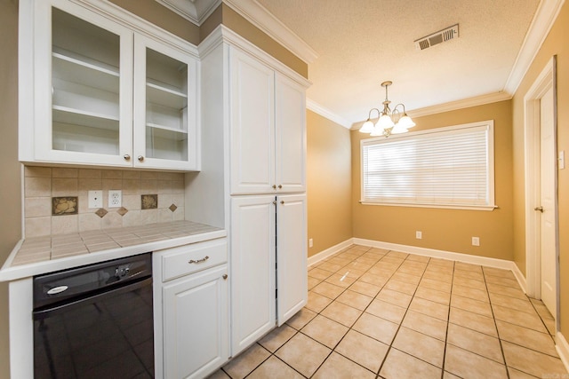 kitchen with tile countertops, white cabinets, and backsplash