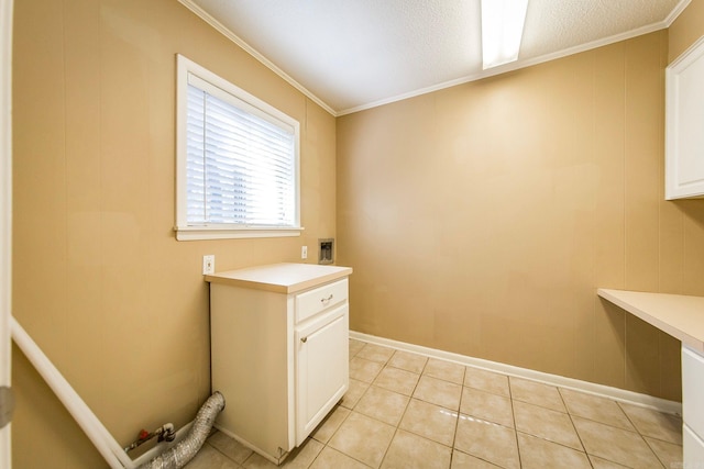 laundry room with crown molding, light tile patterned flooring, and cabinets