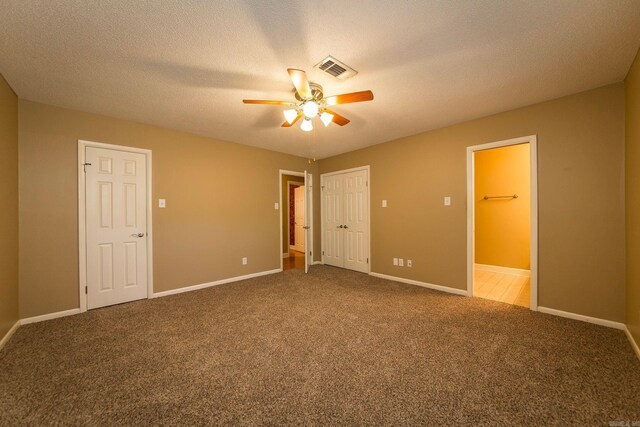 unfurnished bedroom with carpet flooring, a textured ceiling, and ceiling fan