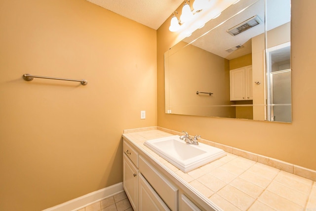 bathroom featuring vanity, a textured ceiling, and tile patterned flooring