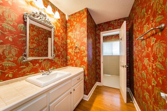 bathroom with vanity, hardwood / wood-style floors, and a textured ceiling