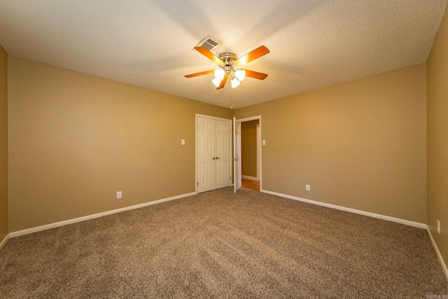 carpeted spare room featuring a textured ceiling and ceiling fan