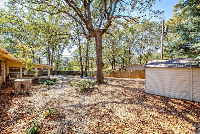 view of yard featuring central AC and a storage unit