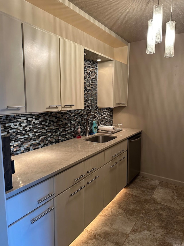 kitchen with hanging light fixtures, backsplash, sink, stainless steel dishwasher, and a textured ceiling