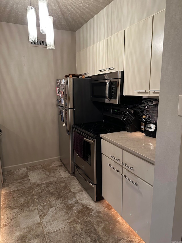 kitchen with white cabinetry, stainless steel appliances, a textured ceiling, and decorative light fixtures