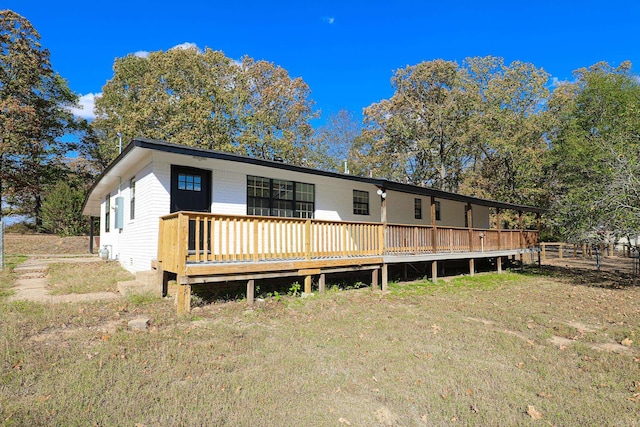 rear view of house with a yard and a deck