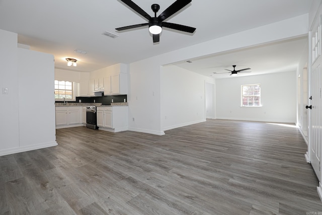 unfurnished living room featuring hardwood / wood-style flooring and a wealth of natural light