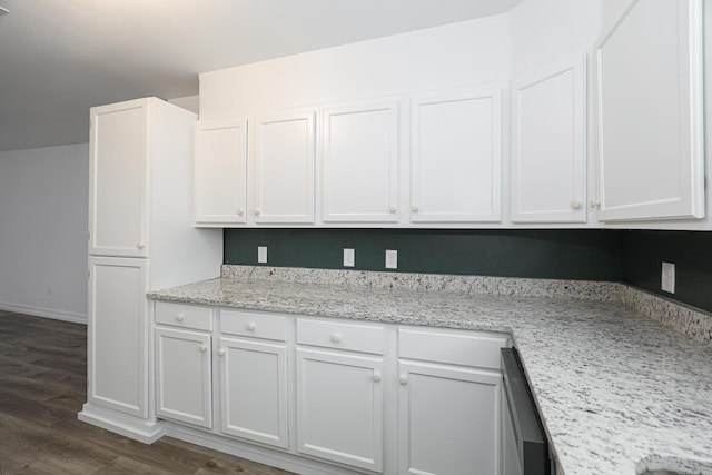 kitchen featuring dark wood-type flooring, white cabinets, light stone counters, and dishwasher