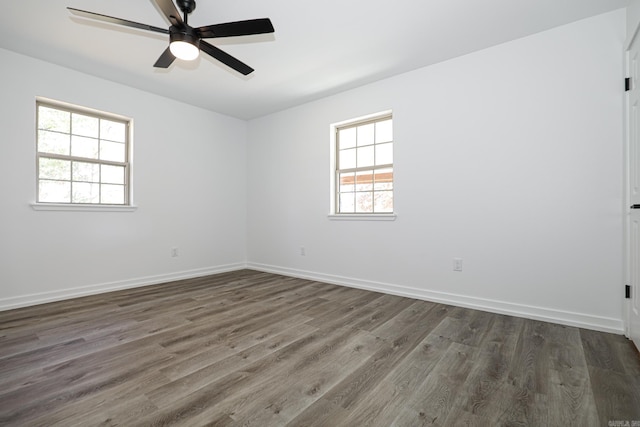 unfurnished room featuring dark hardwood / wood-style flooring, ceiling fan, and a wealth of natural light