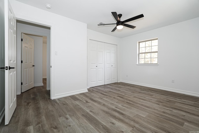 unfurnished bedroom featuring a closet, dark wood-type flooring, and ceiling fan