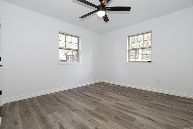 spare room with dark hardwood / wood-style floors, a healthy amount of sunlight, and ceiling fan