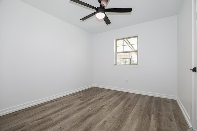 spare room with dark hardwood / wood-style floors and ceiling fan