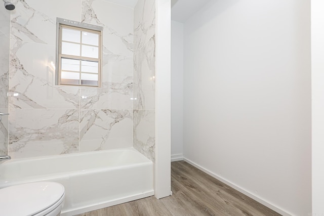 bathroom with toilet, hardwood / wood-style flooring, and tiled shower / bath combo