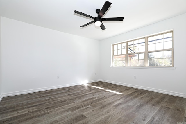 empty room featuring dark wood-type flooring and ceiling fan