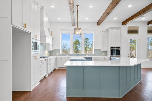 kitchen with decorative backsplash, white cabinets, and a spacious island