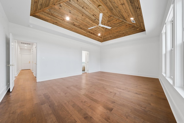 spare room featuring wooden ceiling, wood-type flooring, a tray ceiling, and ceiling fan