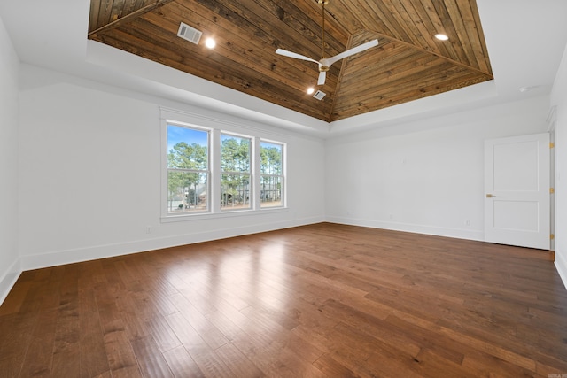 empty room featuring a skylight, dark wood-type flooring, a towering ceiling, and wooden ceiling