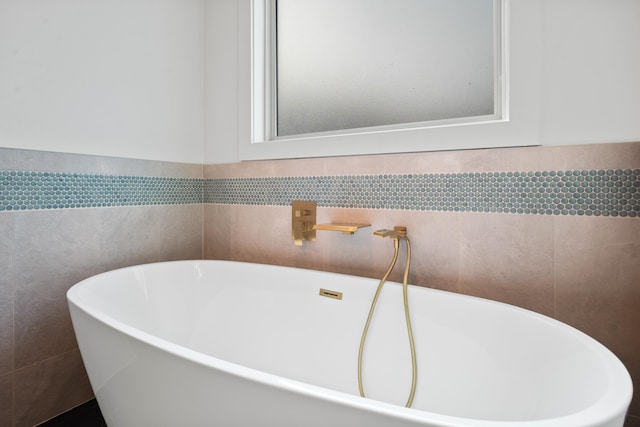 bathroom featuring tile walls and a bathtub